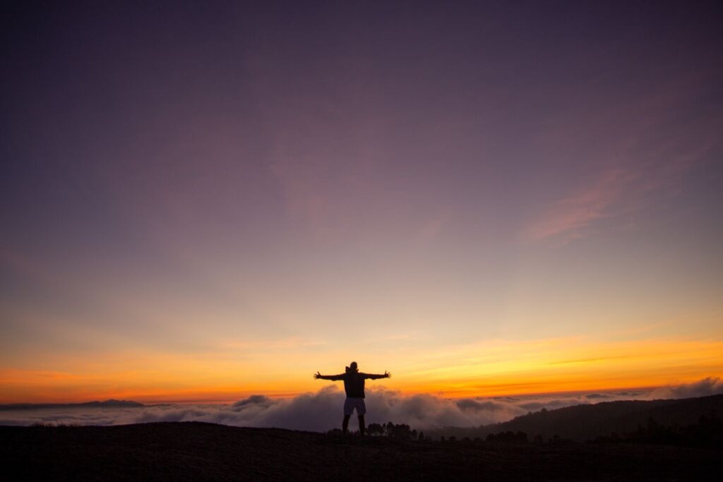 Silhouette of a man standing on a hill at sunrise, symbolizing a fresh start and a 90-day personal reset