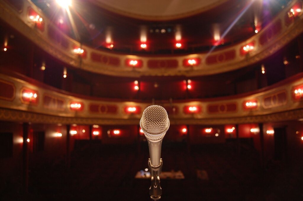 Microphone on a stand facing an empty theater, the moment before speaking with confidence