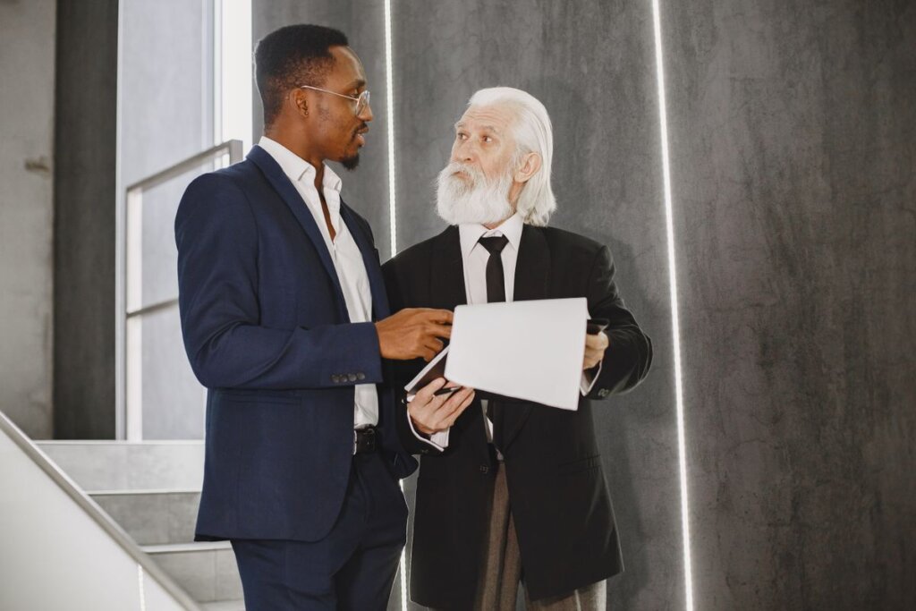 Two professionals reviewing a document together on a staircase, a mentoring and coaching conversation